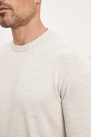 A man wearing a Velvet by Graham & Spencer Palmer Crew Neck Tee made of soft cotton slub knit.