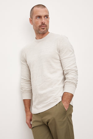 A man wearing a Velvet by Graham & Spencer PALMER CREW NECK TEE and khaki pants.