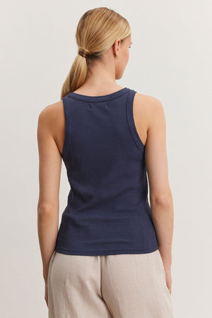 Rear view of a woman wearing a Velvet by Graham & Spencer NOLA tank top and beige pants, standing against a neutral background.