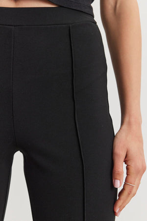 Close-up of a person wearing the ALBEE PONTE PANT by Velvet by Graham & Spencer, featuring visible stitching in stretch ponte fabric, with their right hand resting at their side.