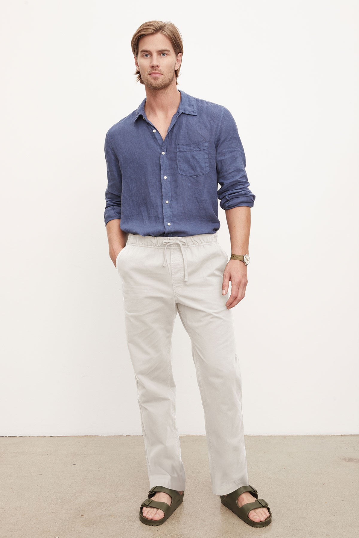   A man in a casual blue shirt and Velvet by Graham & Spencer BRANSON PANT, standing against a plain background. 