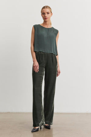 A person wearing a sleeveless dark green top and the Sorine Silk Velvet Pant from Velvet by Graham & Spencer stands against a plain white background.