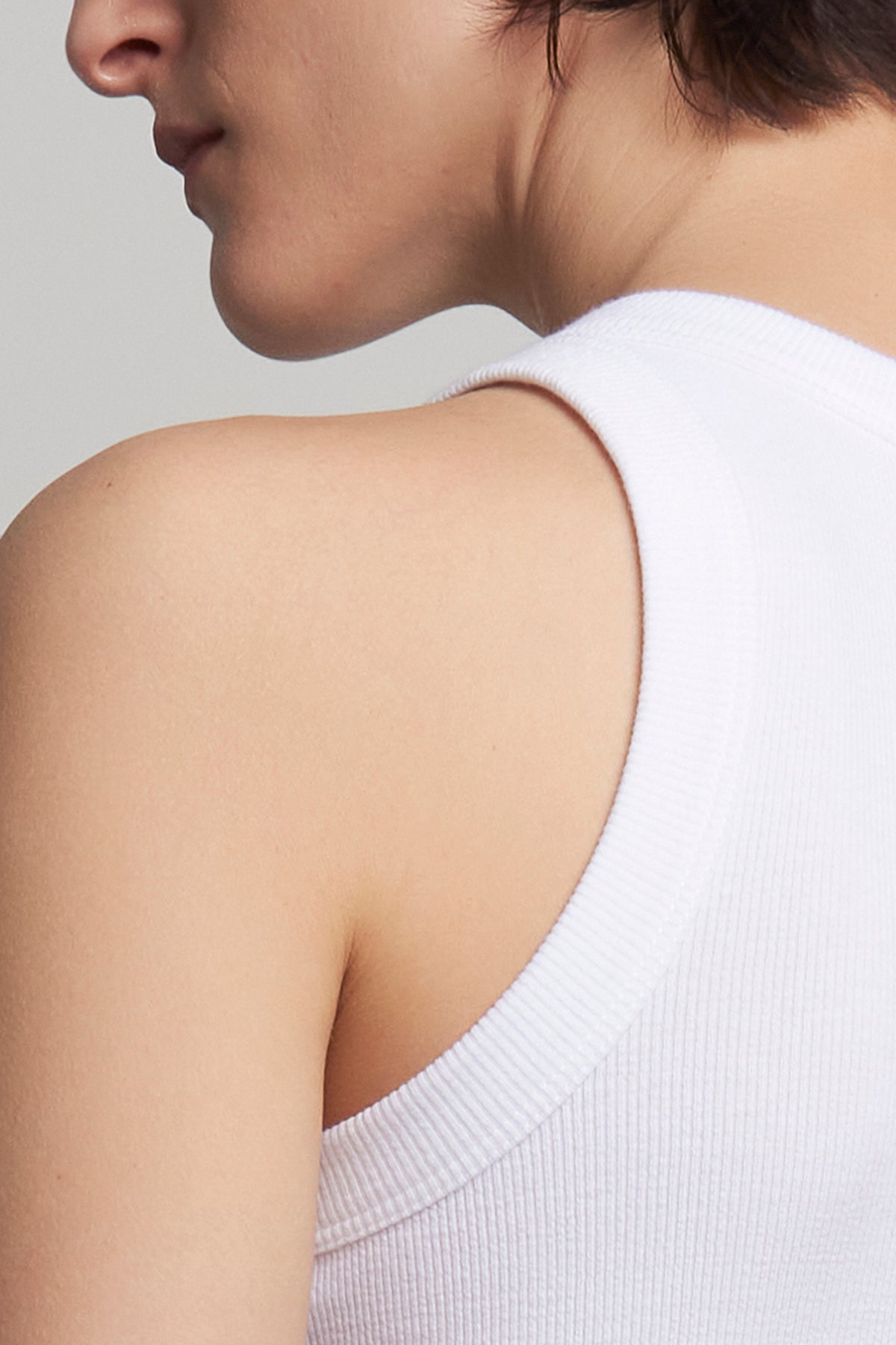   Close-up of a person wearing the CRUZ TANK TOP by Velvet by Jenny Graham, highlighting the back and shoulder. 