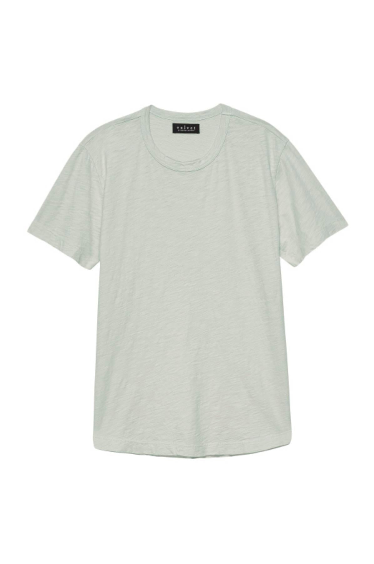   The AMARO TEE by Velvet by Graham & Spencer is a plain, light green short-sleeve T-shirt with a classic crew neckline and a black tag at the back of the collar. Made from lightweight Peruvian cotton, it offers a comfortable fit and a polished finish. 