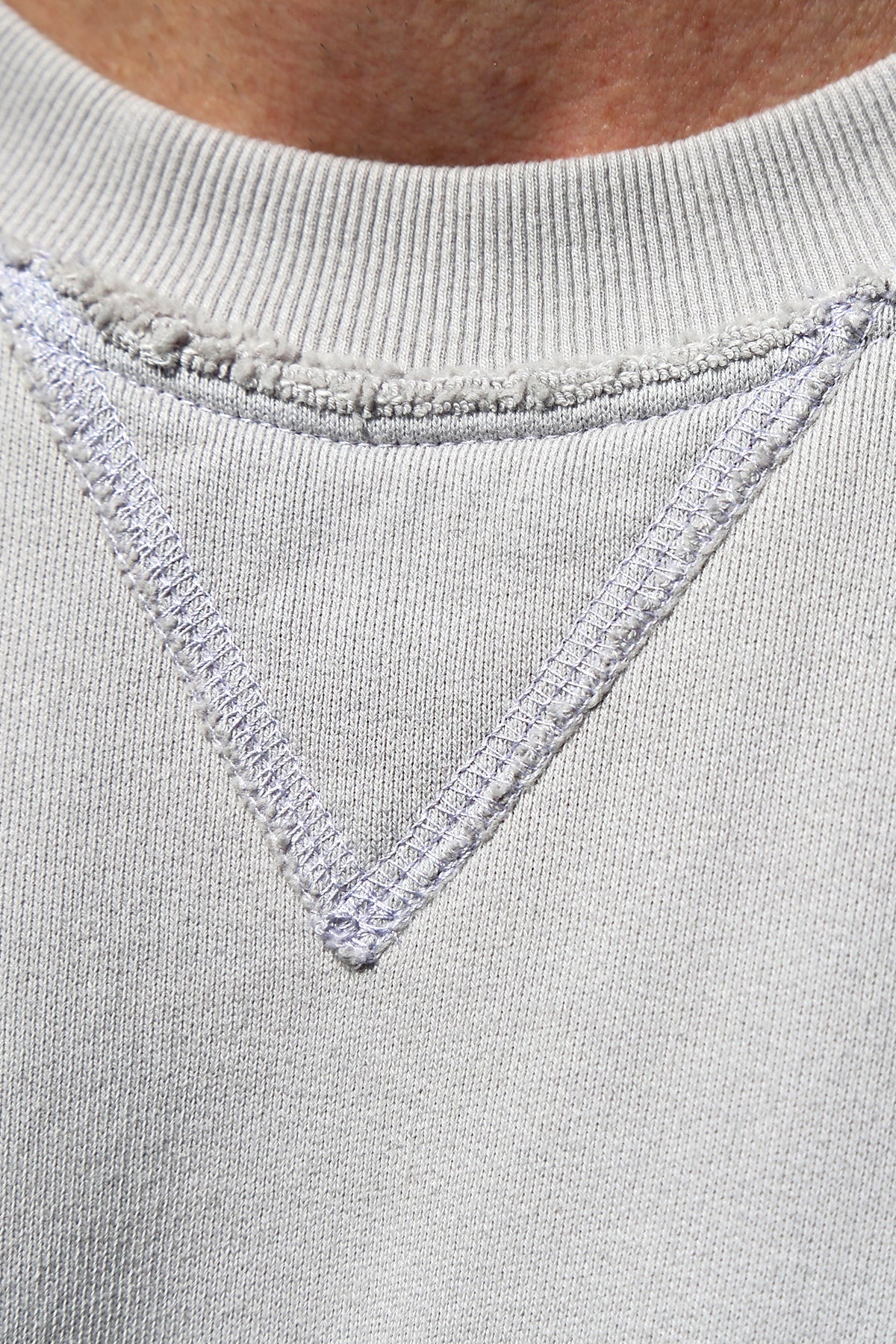   Close-up of the FORREST SWEATSHIRT neckline from Velvet by Graham & Spencer, showcasing a V-shaped stitch design and ribbed trims for added detail in light gray. 