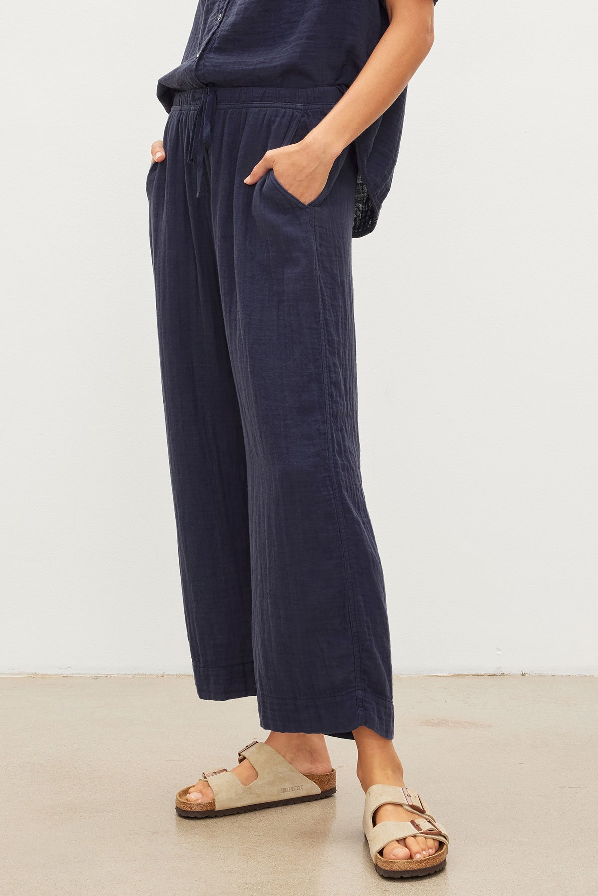   A woman wearing a FRANNY COTTON GAUZE PANT jumpsuit from her closet. (Brand Name: Velvet by Graham & Spencer) 