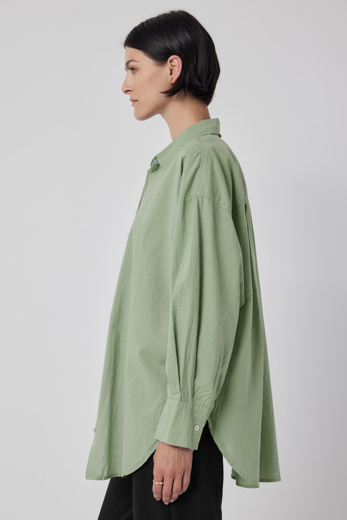   The oversized green Redondo Button-Up Shirt from Velvet by Jenny Graham worn by a woman. 