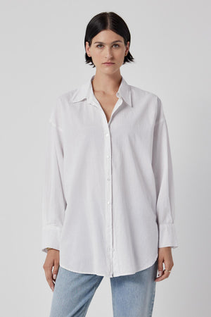 The model is wearing an oversized Velvet by Jenny Graham REDONDO BUTTON-UP SHIRT and jeans.