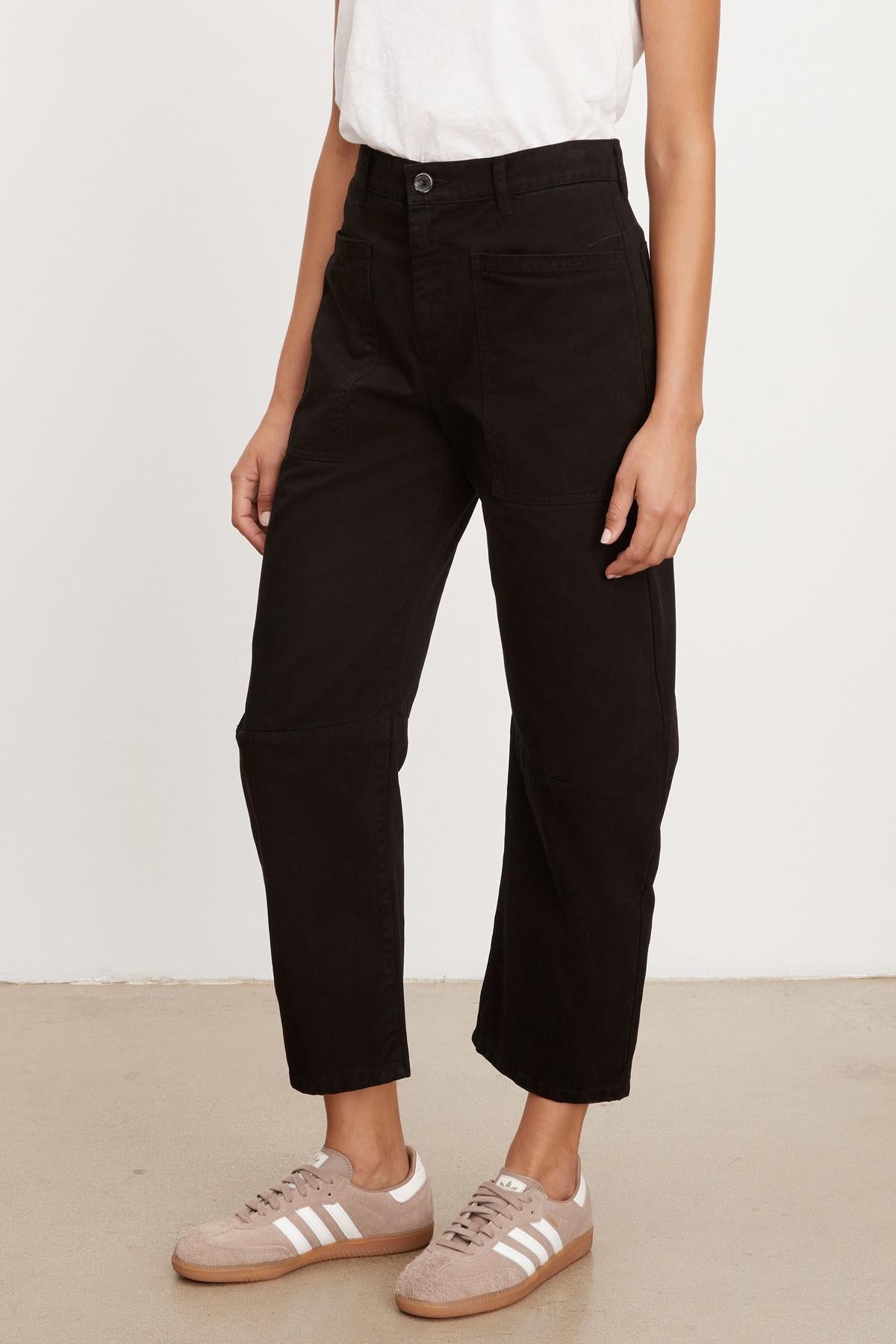   A woman wearing Velvet by Graham & Spencer's BRYLIE SANDED TWILL UTILITY PANT cropped pants and a white t-shirt. 