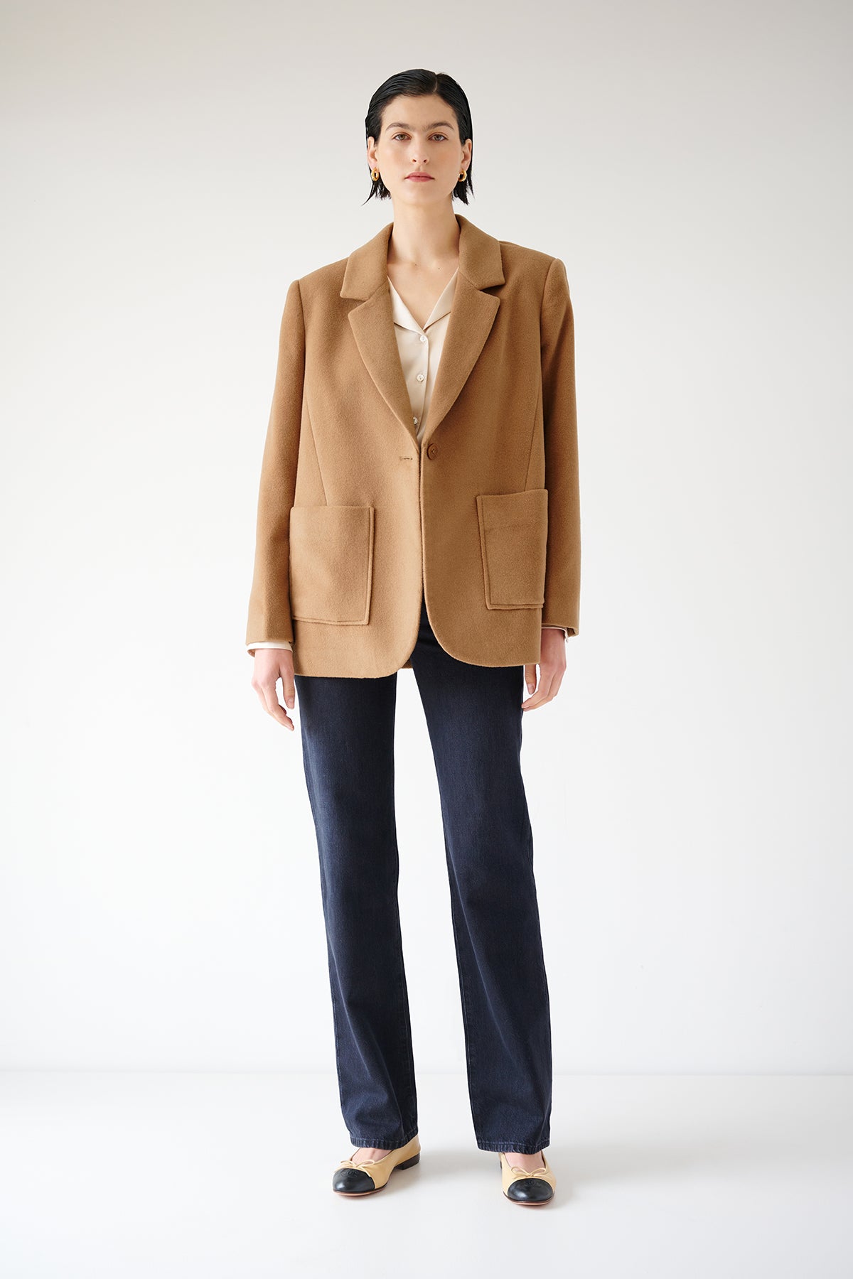   Description: A woman wearing a timeless Velvet by Jenny Graham camel blazer and black pants. 