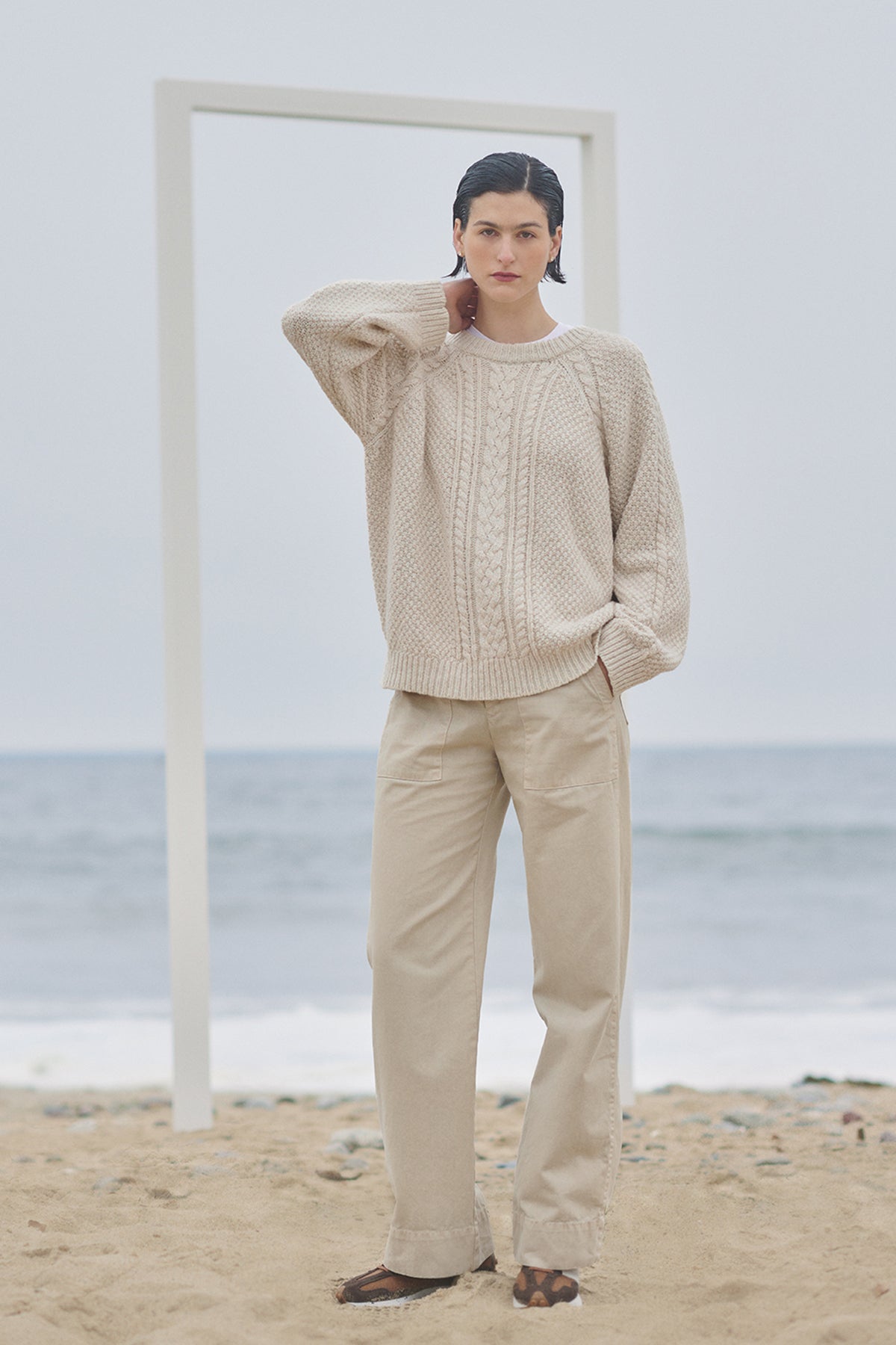   A woman is standing on the beach wearing Velvet by Jenny Graham VENTURA PANT sweater and trousers. 