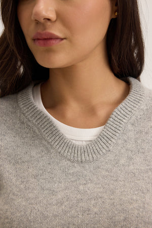 A person wearing the Velvet by Graham & Spencer STEVIE WOOL CASHMERE SWEATER in gray over a white shirt, with dark hair visible on one side.