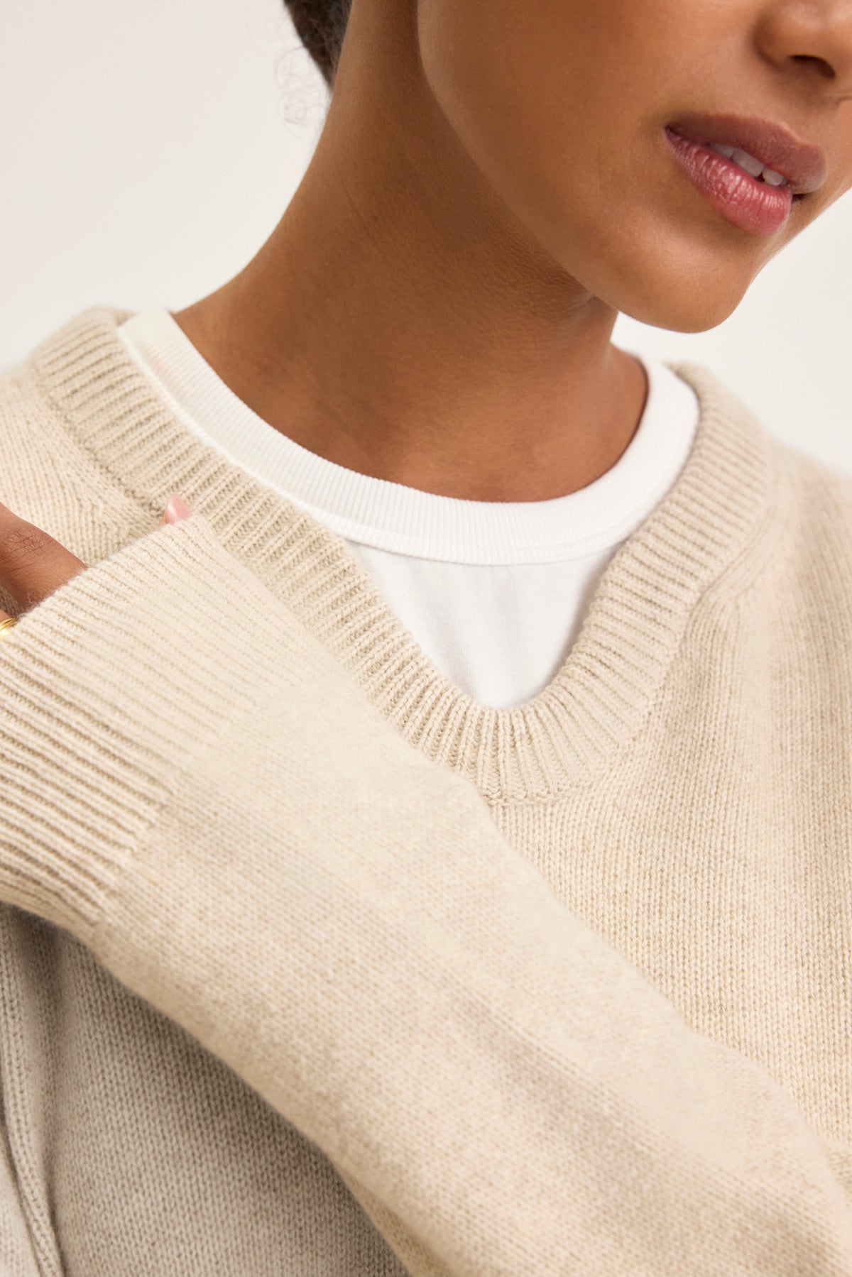   A person stays cozy in the STEVIE WOOL CASHMERE SWEATER by Velvet by Graham & Spencer, a luxurious wool-cashmere blend, layered over a crisp white shirt. 