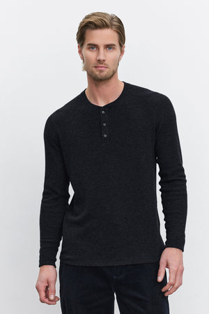 A man with short hair stands against a plain white background, wearing the AMBROSE HENLEY from Velvet by Graham & Spencer. This triblend cozy thermal fabric henley features a three-button placket.