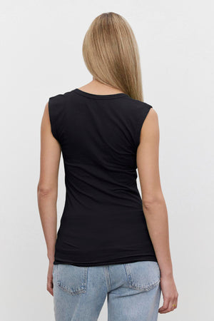 A person with long, straight hair is shown from the back, wearing a black ESTINA TANK TOP by Velvet by Graham & Spencer and light blue jeans against a plain white background.