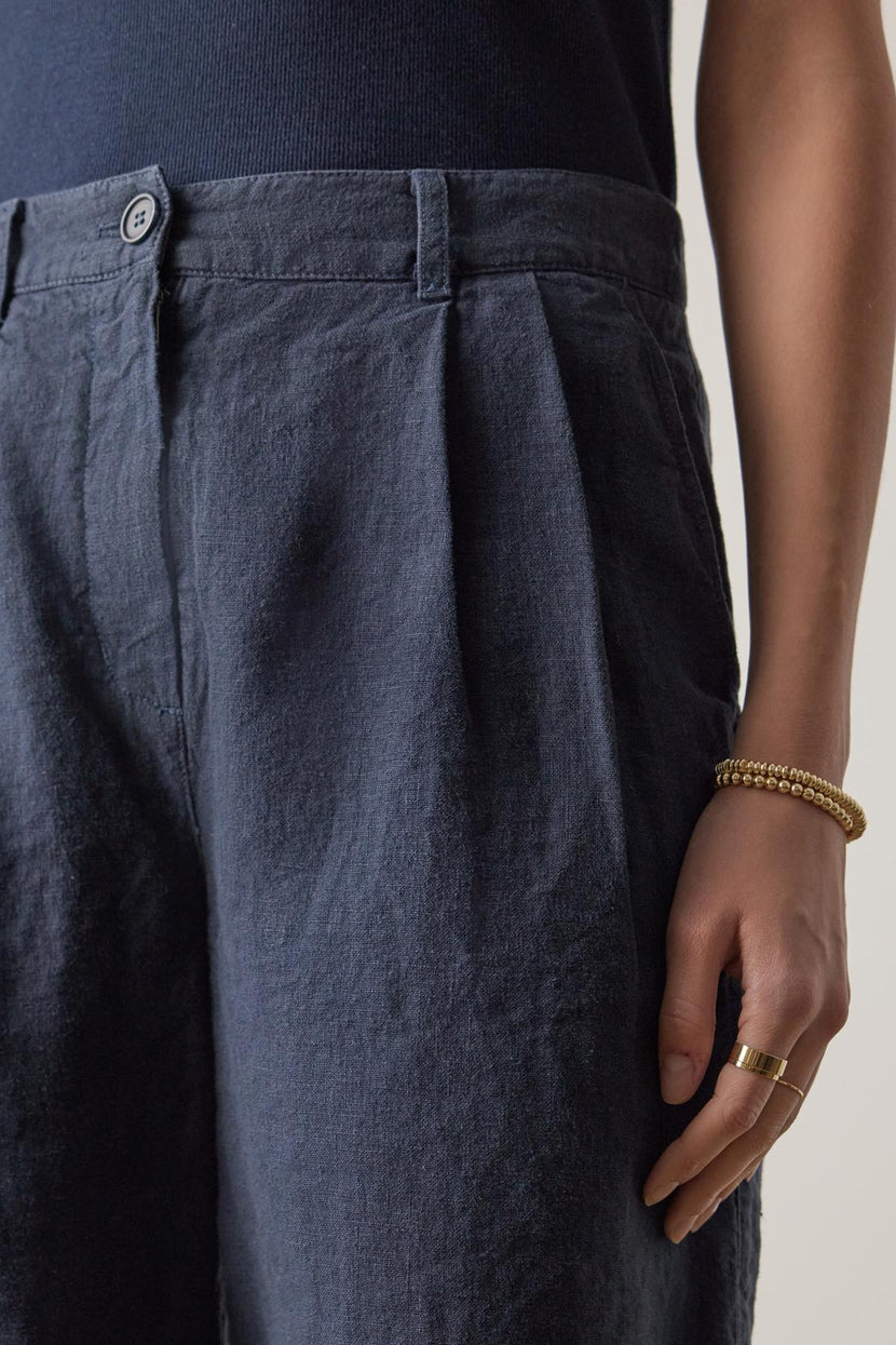 Close-up of a person wearing Velvet by Jenny Graham's LARCHMONT HEAVY LINEN SHORT with a hand resting on the hip, showcasing a golden bracelet and ring.