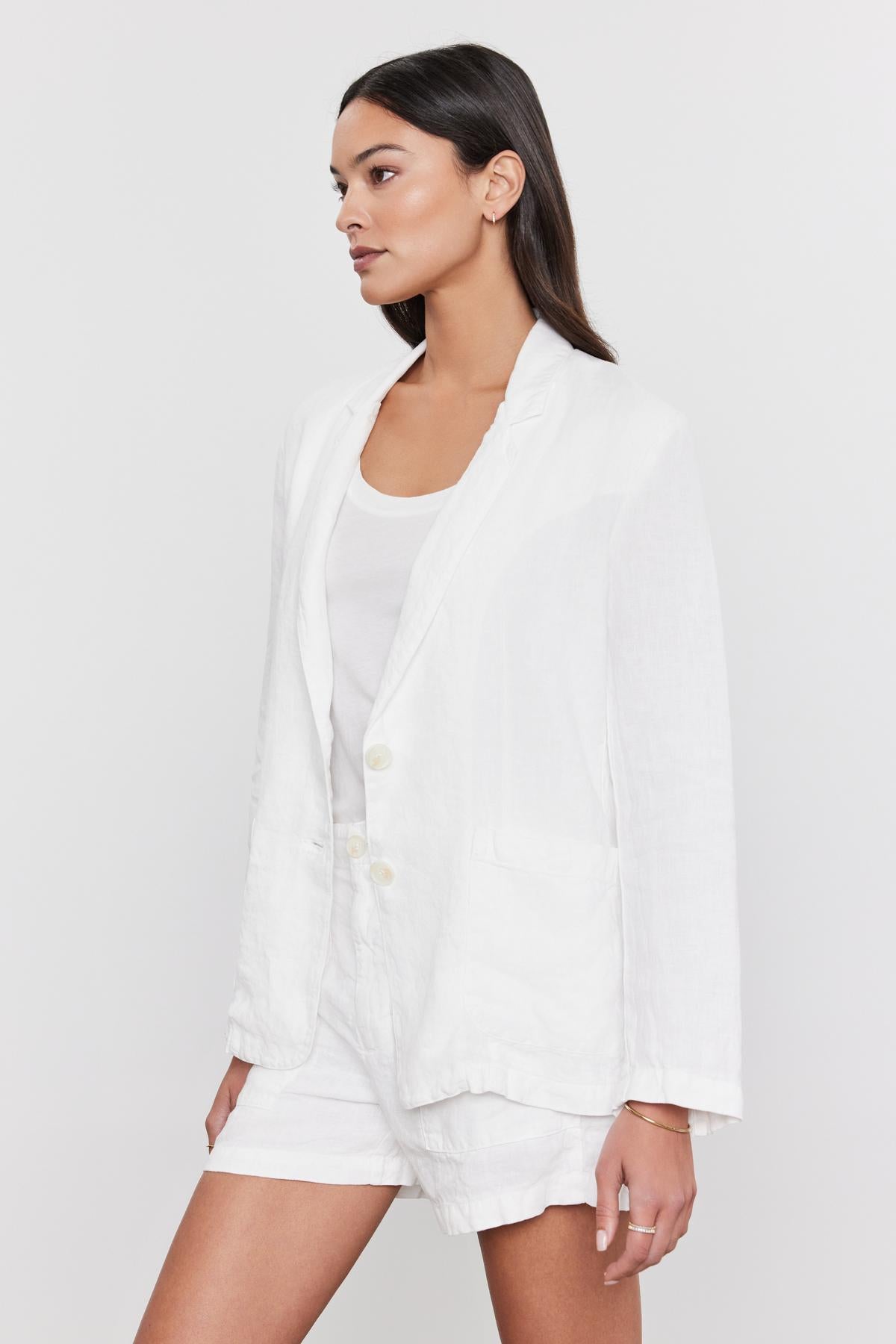 A woman in a Velvet by Graham & Spencer Lenny Heavy Linen Blazer and heavy linen pants, wearing a white t-shirt, looking to her right with a neutral expression.-36910096351425