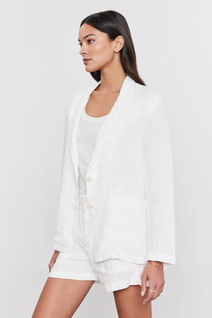 A woman in a Velvet by Graham & Spencer Lenny Heavy Linen Blazer and heavy linen pants, wearing a white t-shirt, looking to her right with a neutral expression.