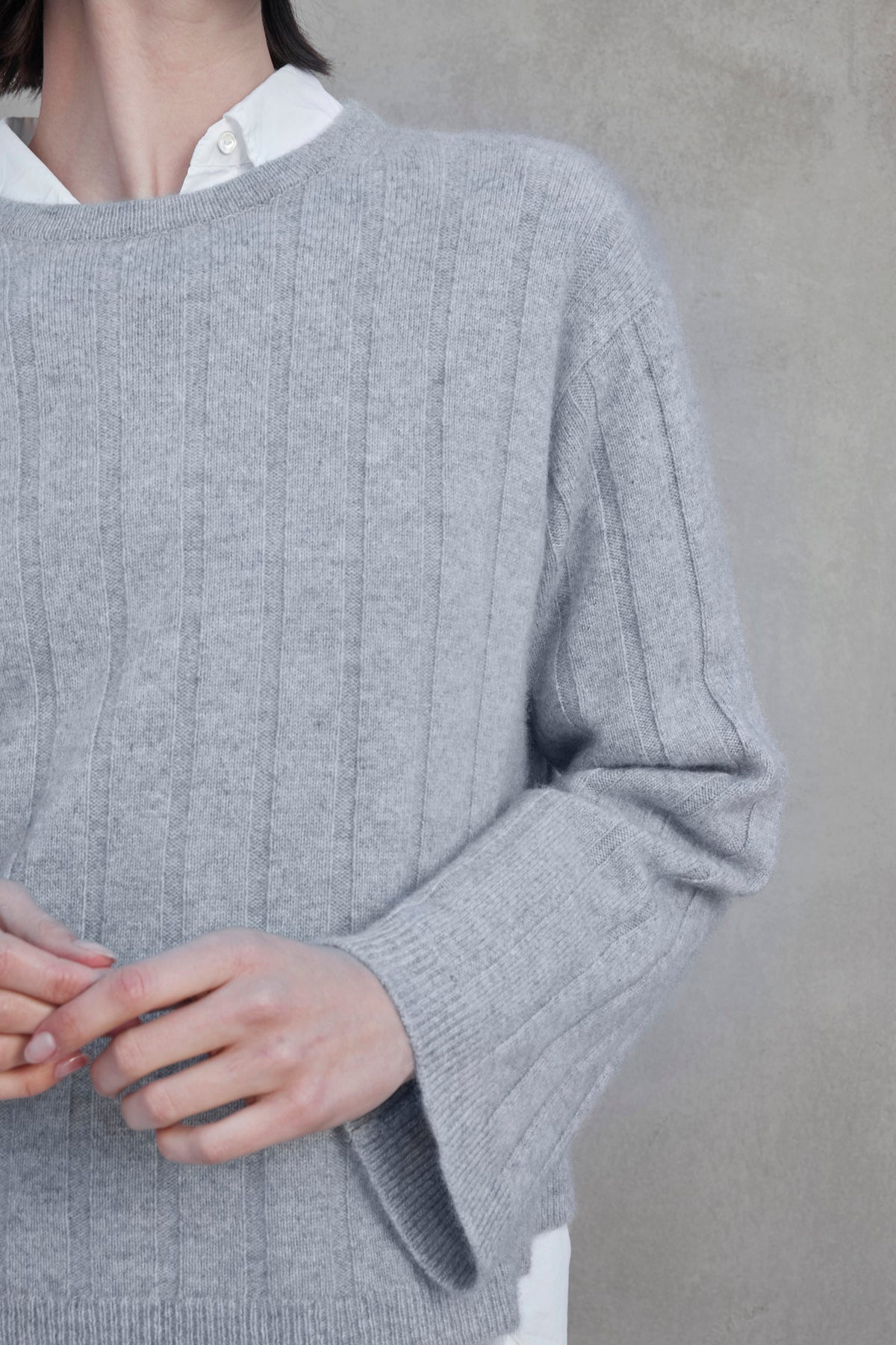 A person wearing a light gray FILLMORE CASHMERE SWEATER by Velvet by Jenny Graham over a white collared shirt, with their hands partially visible at the bottom of the image.-37659908178113