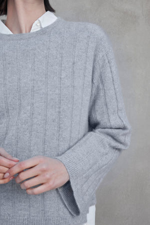 A person wearing a light gray FILLMORE CASHMERE SWEATER by Velvet by Jenny Graham over a white collared shirt, with their hands partially visible at the bottom of the image.