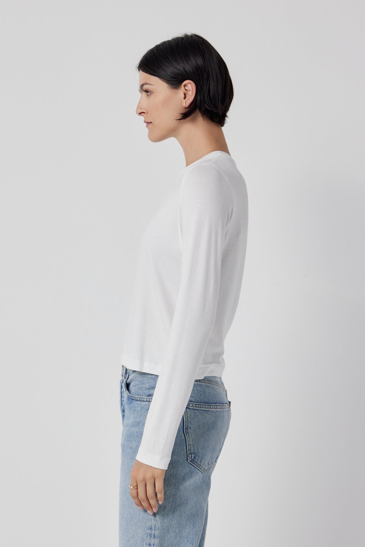   The back view of a woman wearing Velvet by Jenny Graham stretch jeans and a white long sleeved Pacifica Tee. 