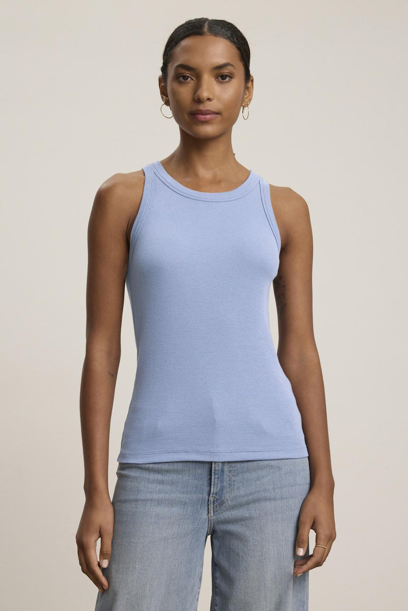 A person is wearing the CRUZ TANK TOP by Velvet by Jenny Graham, a light blue, ribbed cotton-modal blend tank, paired with jeans against a plain background.