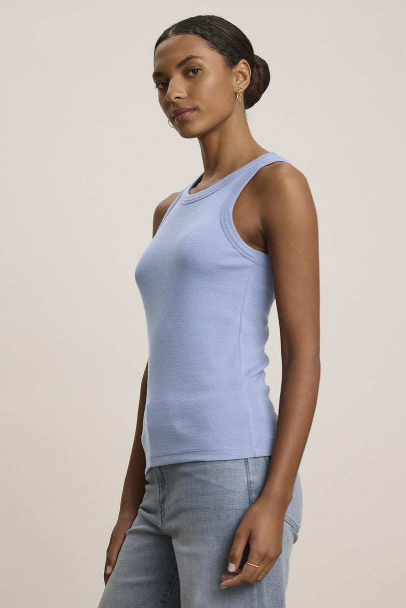 A person wears the versatile CRUZ TANK TOP by Velvet by Jenny Graham, paired with jeans against a neutral background, showcasing an ideal piece for a capsule wardrobe.