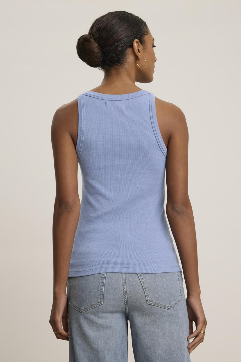 Someone is shown from the back wearing a versatile CRUZ TANK TOP by Velvet by Jenny Graham in light blue, paired with jeans, against a plain background.