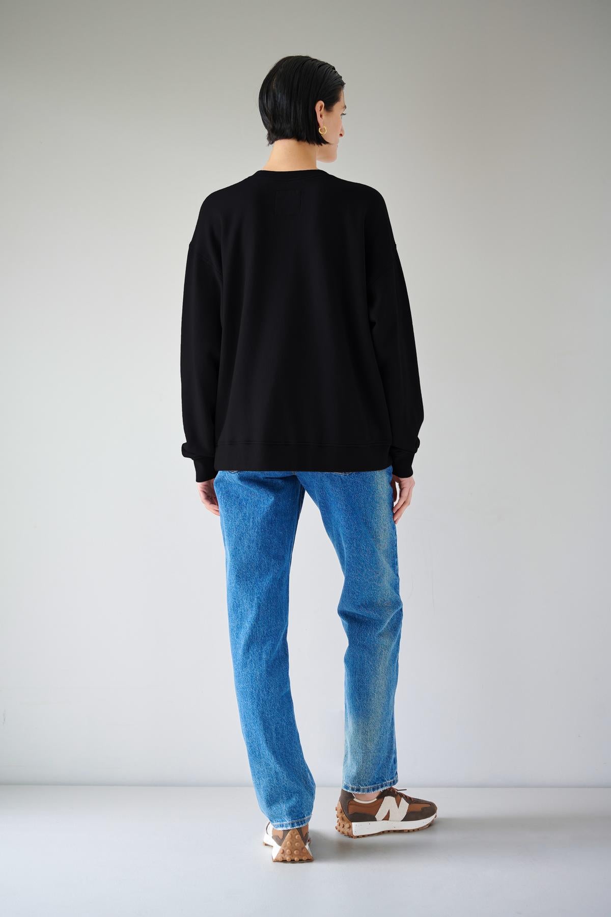   The slouchy back view of a woman rocking organic cotton jeans and an Abbot sweatshirt from Velvet by Jenny Graham with styling versatility. 