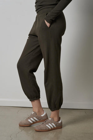 A woman wearing a pair of Velvet by Jenny Graham ZUMA SWEATPANTS and eco-friendly sneakers.