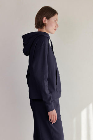 The back view of a woman wearing a Velvet by Jenny Graham OJAI HOODIE.