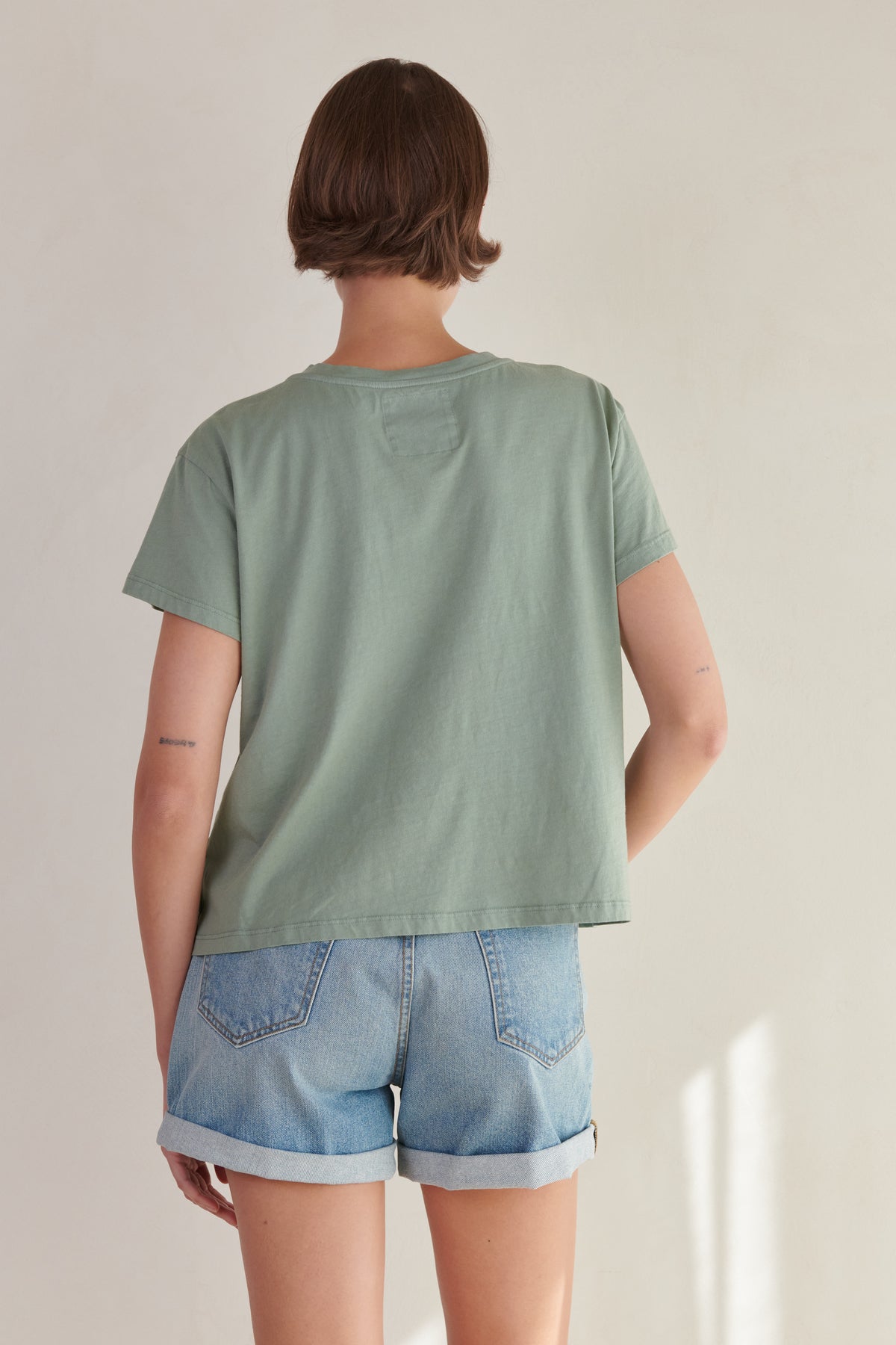   the back view of a woman wearing denim shorts and a Velvet by Jenny Graham TOPANGA TEE. 