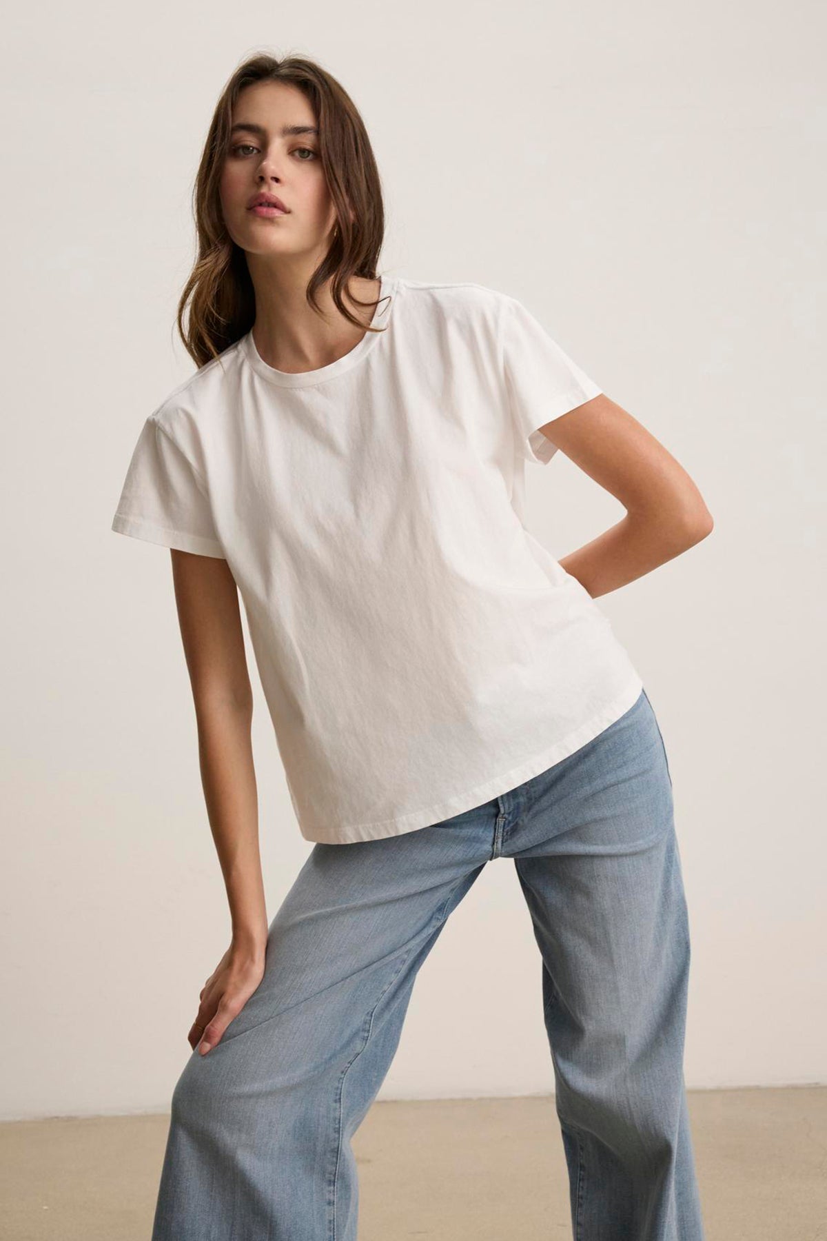   A person wearing the TOPANGA TEE by Velvet by Jenny Graham, paired with blue jeans, poses in front of a plain background. 