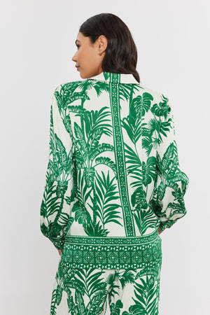 Woman seen from the back wearing a white and green palm print AYLA BUTTON-UP SHIRT with long sleeves, standing against a plain background. Brand name: Velvet by Graham & Spencer