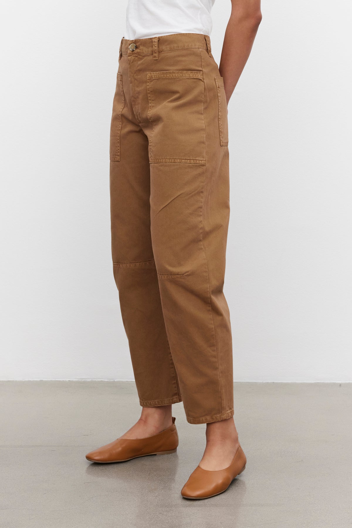 Person wearing BRYLIE SANDED TWILL UTILITY PANTS by Velvet by Graham & Spencer and a white shirt, standing on a gray floor.-37676285624513