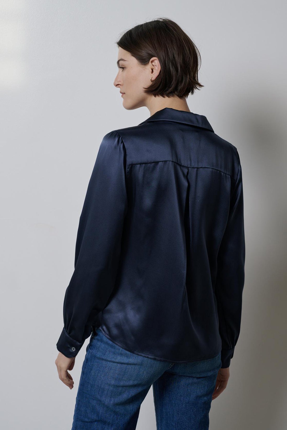   The back view of a timeless woman wearing a Velvet by Jenny Graham navy silk charmeuse SOHO TOP. 