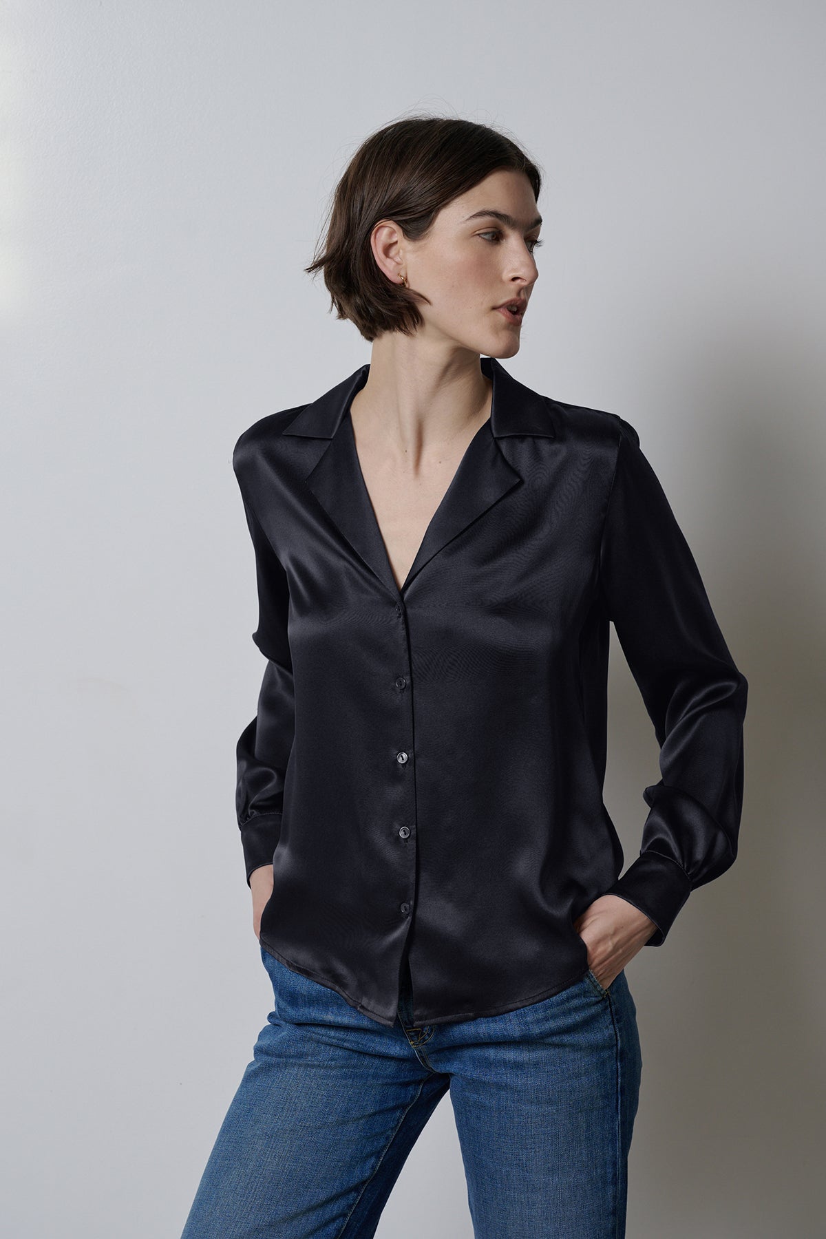   The model is wearing a timeless SOHO TOP blouse from Velvet by Jenny Graham with button-up detailing, paired with jeans. 