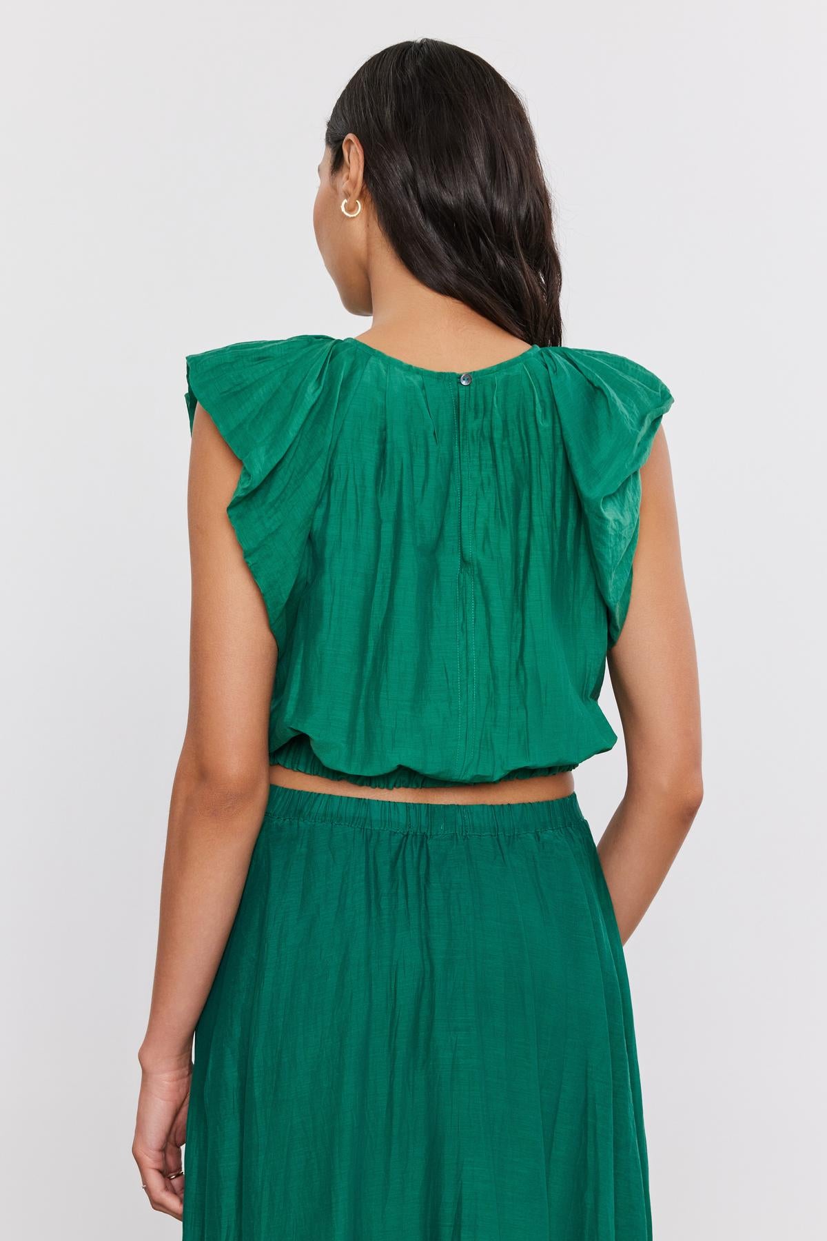 A woman viewed from behind wearing a Velvet by Graham & Spencer AMORA TOP with a crew neckline and matching skirt, standing against a plain white background.-36910240432321