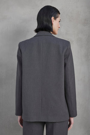 A person with short black hair is shown from behind wearing the Velvet by Jenny Graham REXFORD BLAZER and matching pants against a plain gray background.