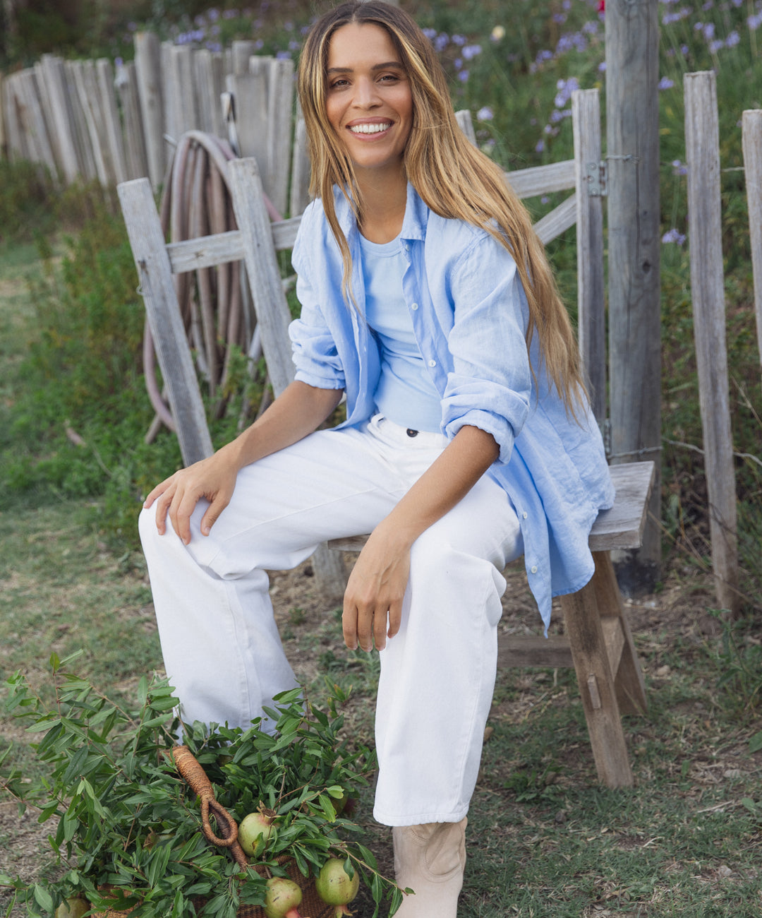 Cleo Wade wearing the Sisi Shirt in Chill from the Easeful Essentials collaboration with Velvet by Graham & Spencer in an outdoor garden setting.