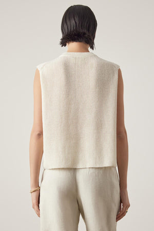 Person with short dark hair seen from the back, wearing the Velvet by Jenny Graham GARDENA LINEN SWEATER VEST and light-colored pants, crafted from breathable linen for a relaxed fit.