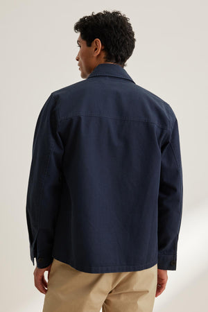 A person with short dark hair wears a Velvet by Graham & Spencer STEEL CHORE JACKET and beige pants, viewed from the back against a plain background.