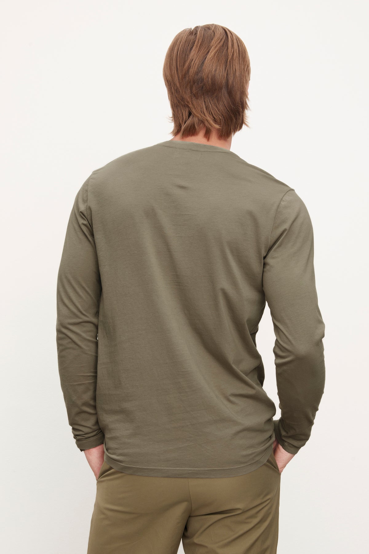A person with shoulder-length hair wearing an olive green ALVARO HENLEY by Velvet by Graham & Spencer and matching pants is standing with their back facing the camera.-36009056436417