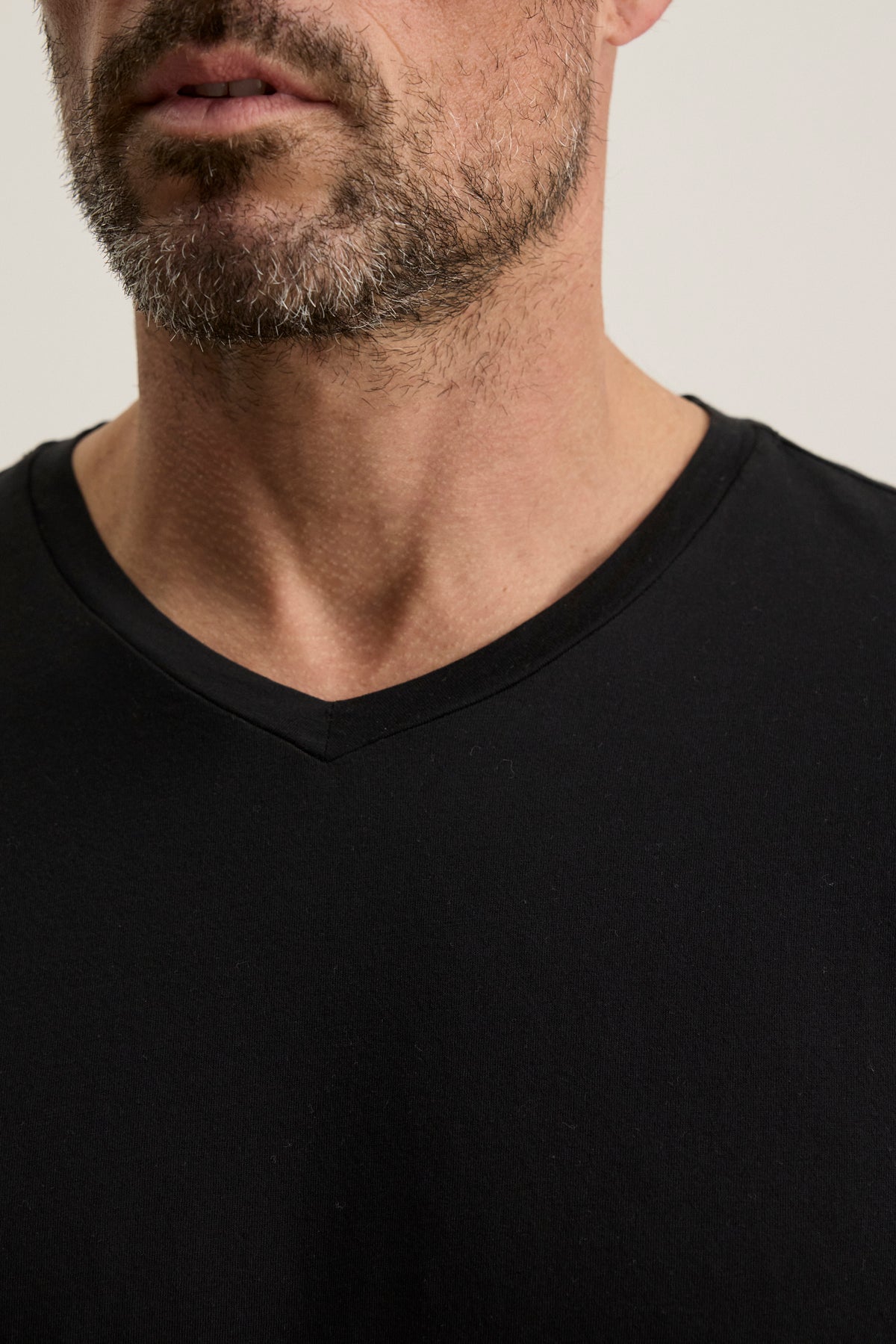 A close-up of a man wearing the SAMSEN TEE by Velvet by Graham & Spencer, showcasing its rich Pima jersey fabric and highlighting his beard and neck.-38504012480705