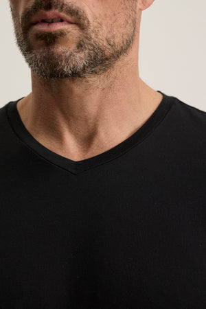 A close-up of a man wearing the SAMSEN TEE by Velvet by Graham & Spencer, showcasing its rich Pima jersey fabric and highlighting his beard and neck.