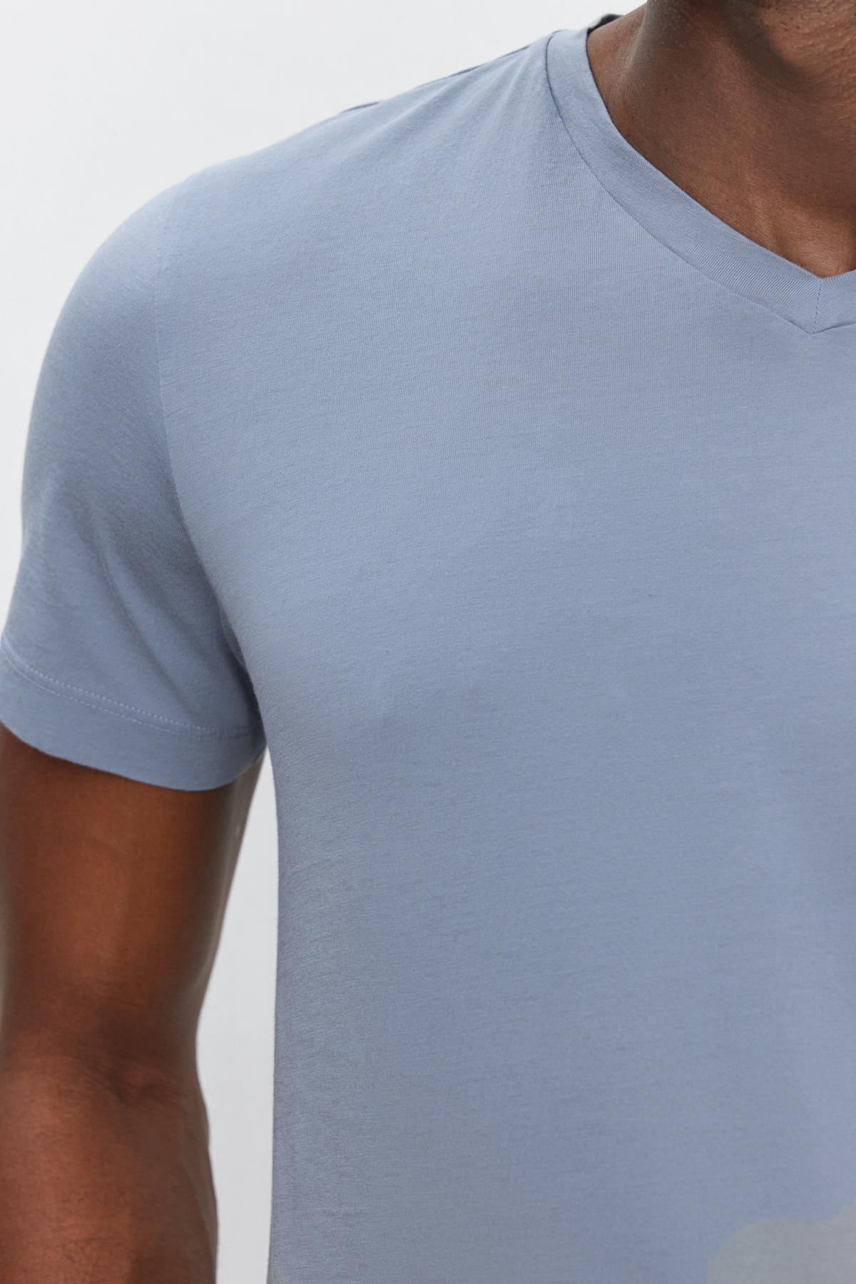   Close-up of a person wearing a SAMSEN TEE by Velvet by Graham & Spencer, showing part of the chest, shoulder, and upper arm against a white background. Perfect for everyday wear. 