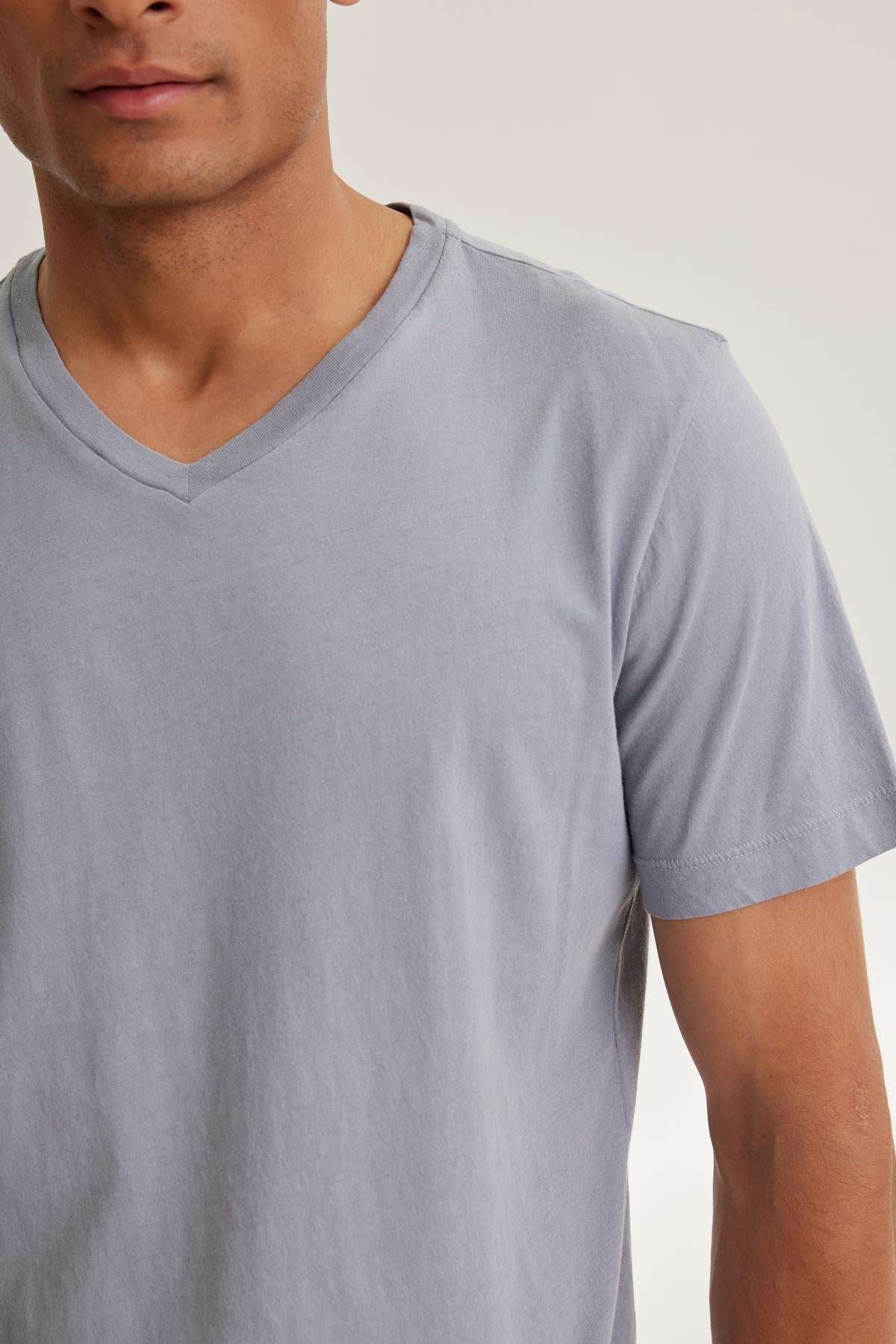   A person wearing the SAMSEN TEE by Velvet by Graham & Spencer, a soft Pima jersey V-neck T-shirt, against a neutral background—ideal for effortless layering. 