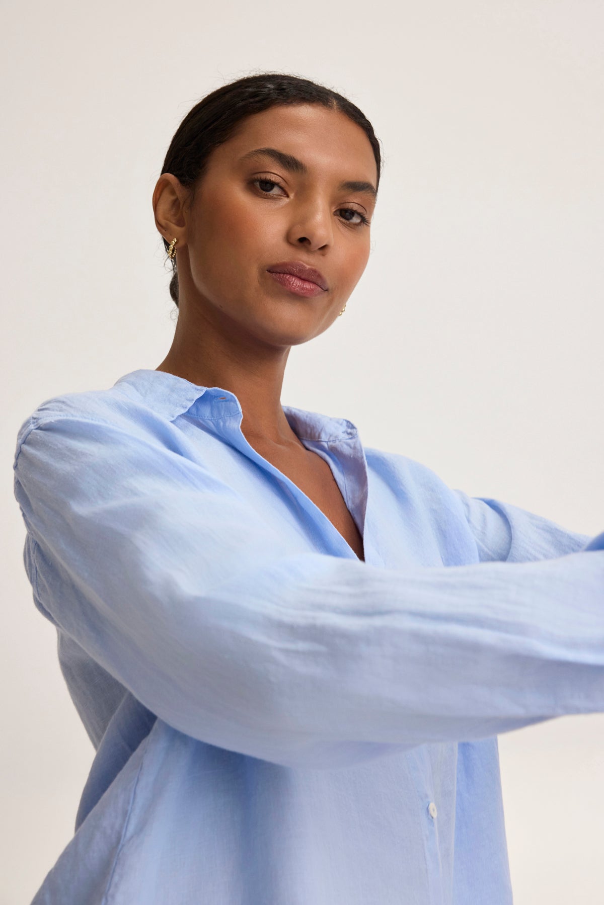 A person wearing a Velvet by Graham & Spencer SISI LINEN SHIRT with a breathable fit, looking at the camera against a plain background.-38819773022401