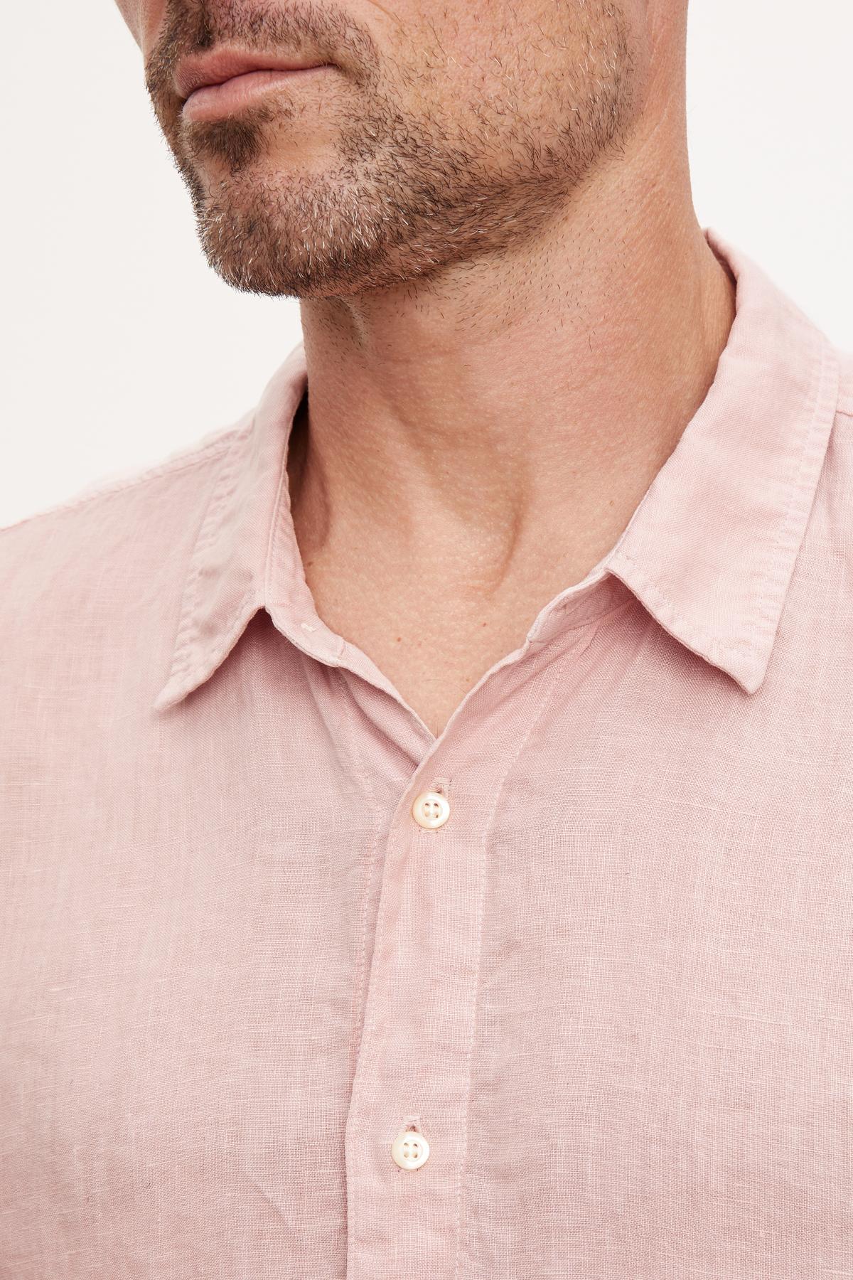   Close-up of a man wearing a Velvet by Graham & Spencer MACKIE LINEN BUTTON-UP SHIRT with focus on the collar and top buttons. 