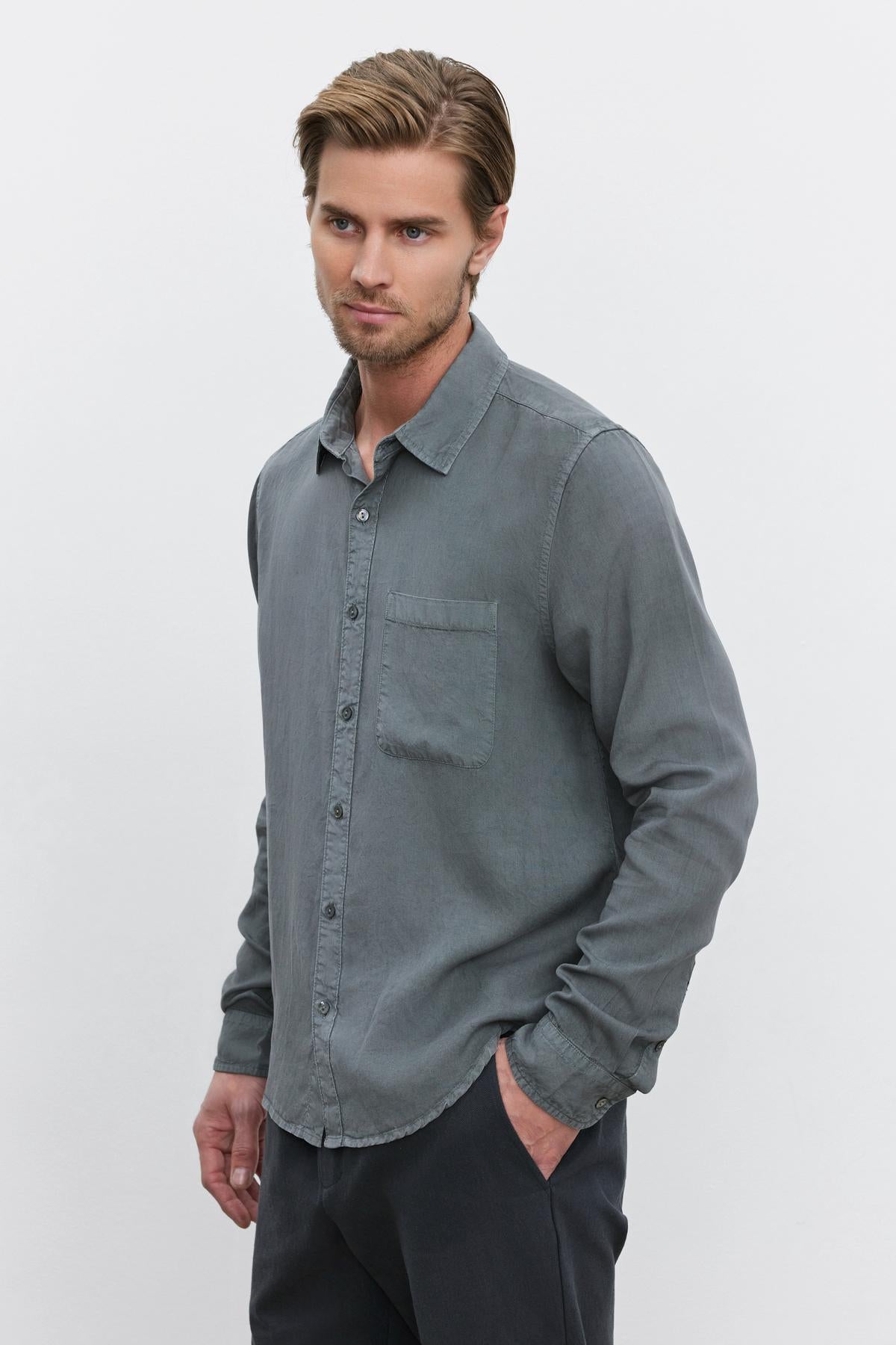   A man with light brown hair and a beard wearing the WOLF BUTTON-UP SHIRT by Velvet by Graham & Spencer stands against a white background. 